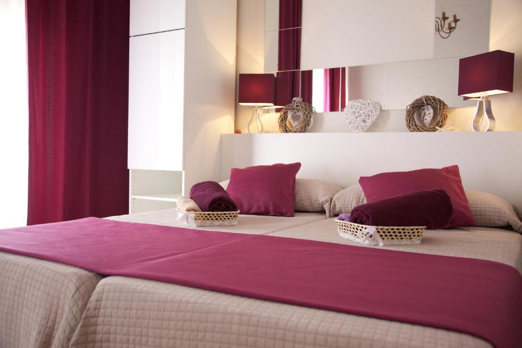 a bedroom with a large bed with purple sheets at Apartamentos Plaza de Austria in Córdoba