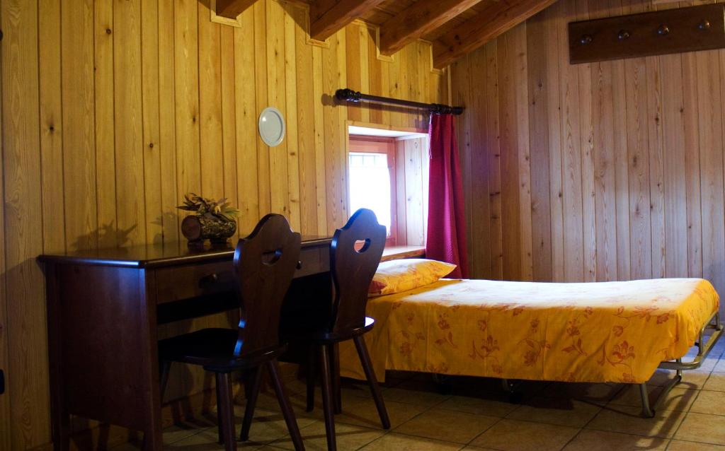 sypialnia z łóżkiem, biurkiem, łóżkiem i stołem w obiekcie Locanda Lac Place Moulin w mieście Bionaz