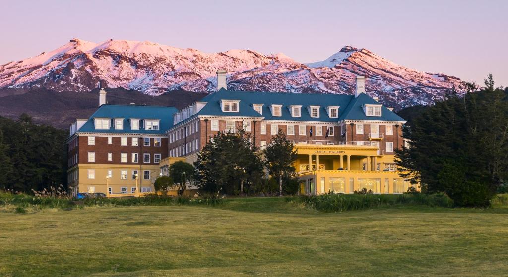 a large building with a mountain in the background at Chateau Tongariro Hotel in Whakapapa Village