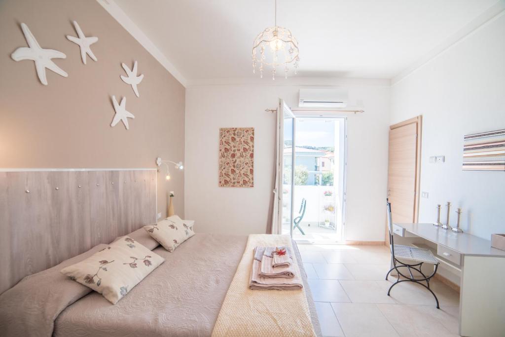 a white bedroom with a large bed and a desk at B&B Nell'Isola in Carloforte