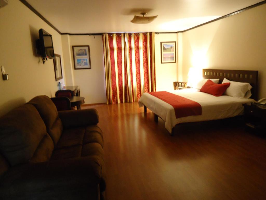 ein Hotelzimmer mit einem Bett und einem Sofa in der Unterkunft Hotel Plaza San Carlos in Xicotepec de Juárez