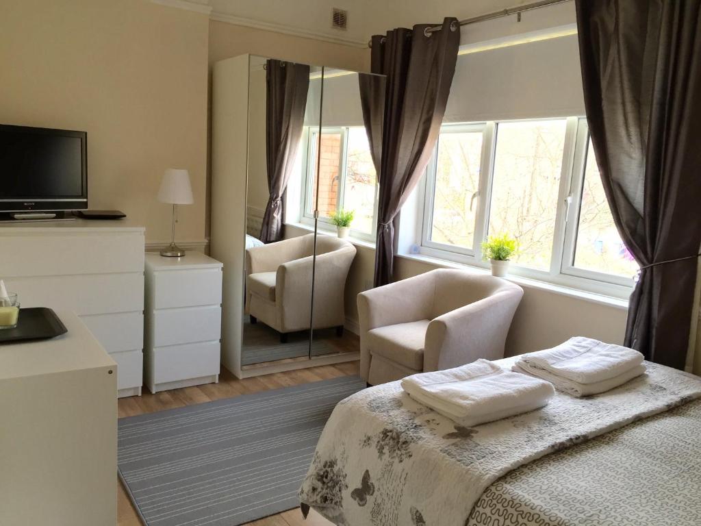 a bedroom with a bed and two chairs and a mirror at Be My Guest Liverpool in Liverpool