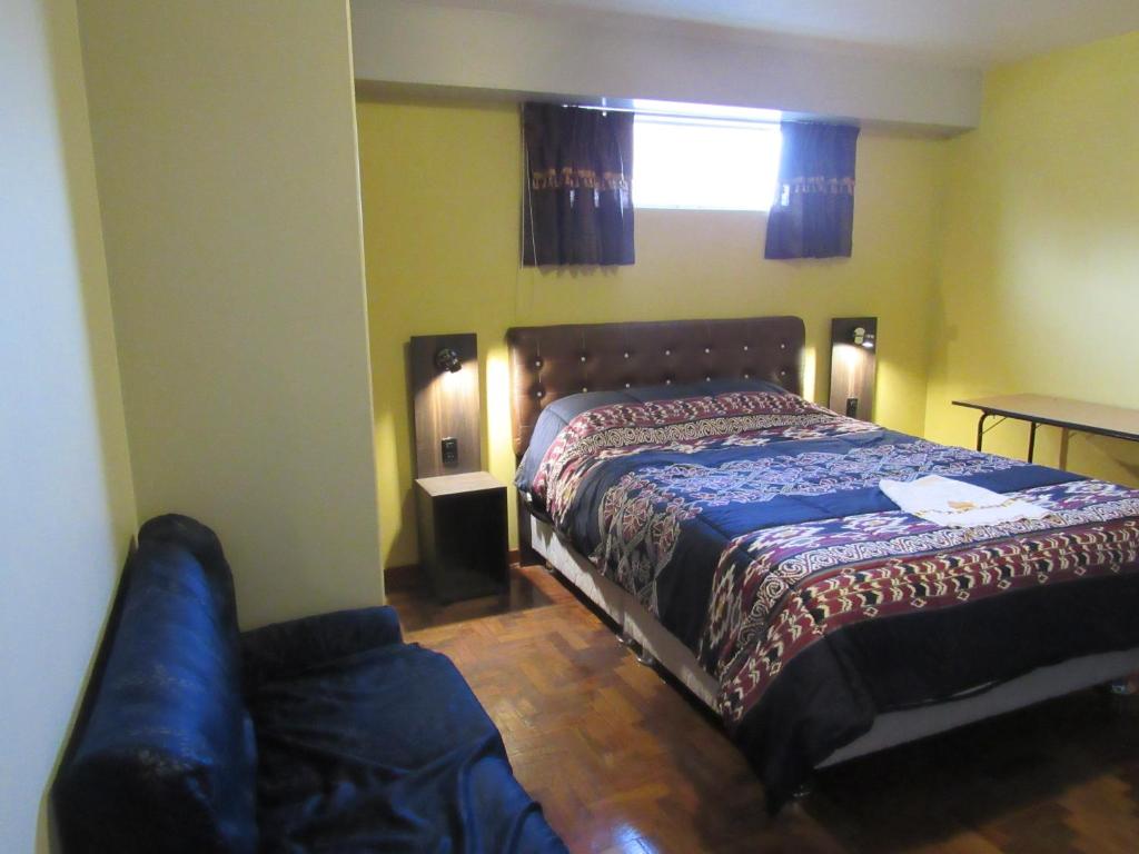 1 dormitorio con cama y sofá en Hotel Sueños Dorados, en Juliaca
