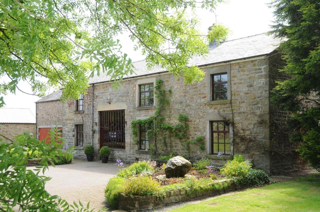 an old stone house with a garden in front of it at Green Bank Farmhouse in Lancaster