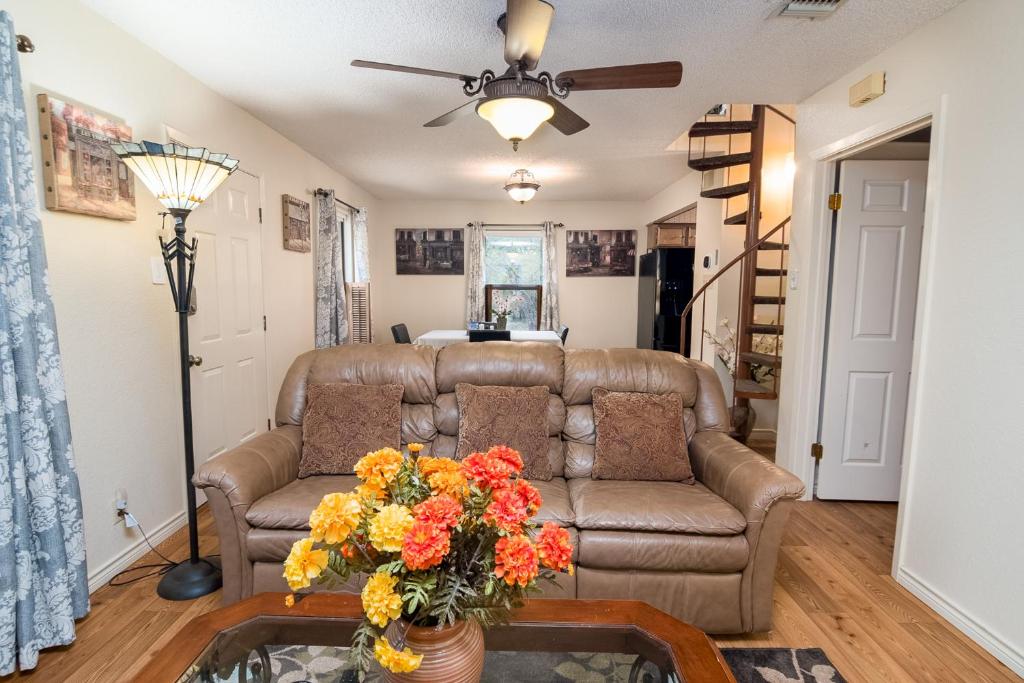 ein Wohnzimmer mit einem Sofa und einem Tisch mit Blumen in der Unterkunft Home away from Home No City Tax in San Antonio