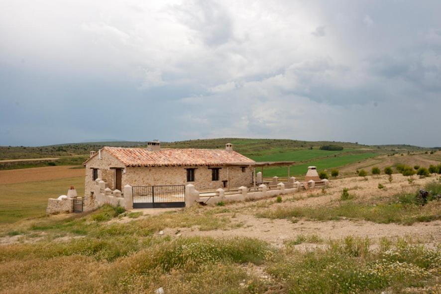 um edifício antigo no meio de um campo em Masada Andabe em Las Cuevas de Cañart