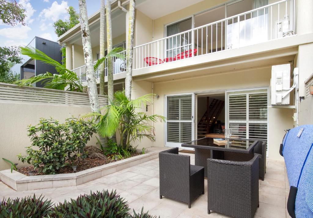 a balcony of a house with a table and chairs at Moondarah Apartment 6, Noosa Heads in Noosa Heads