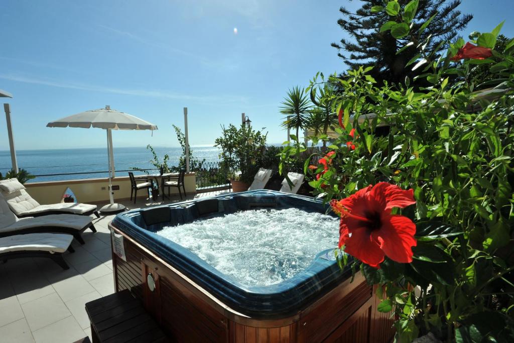 uma banheira de hidromassagem num pátio com uma flor vermelha em E Poi...Ravello em Ravello