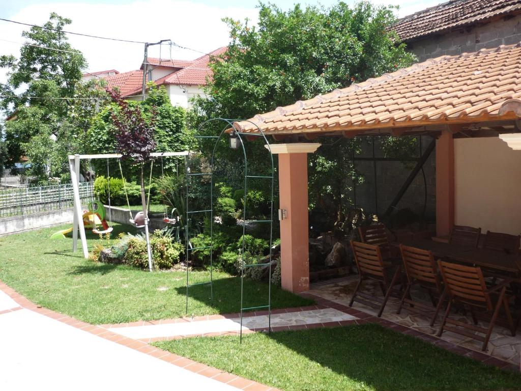 einen Garten mit Stühlen und einem Pavillon in der Unterkunft Erodios Guesthouse in Kato Loutraki