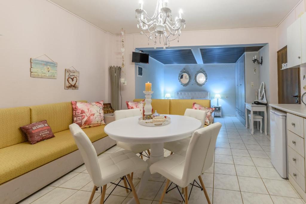 a living room with a couch and a table and chairs at Olympus Studios in Malia