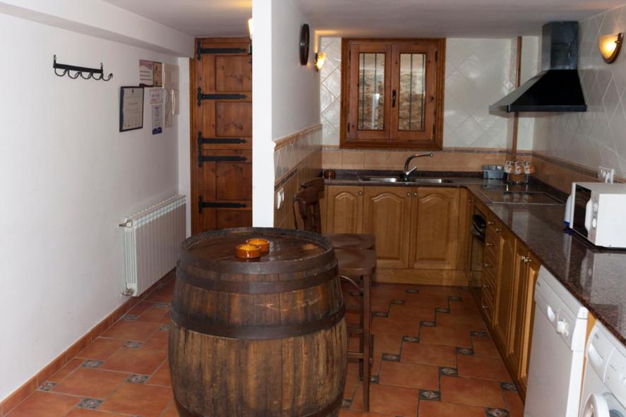 a kitchen with a large wooden barrel in the middle of it at Casa Rural Benito in Las Cuevas de Cañart