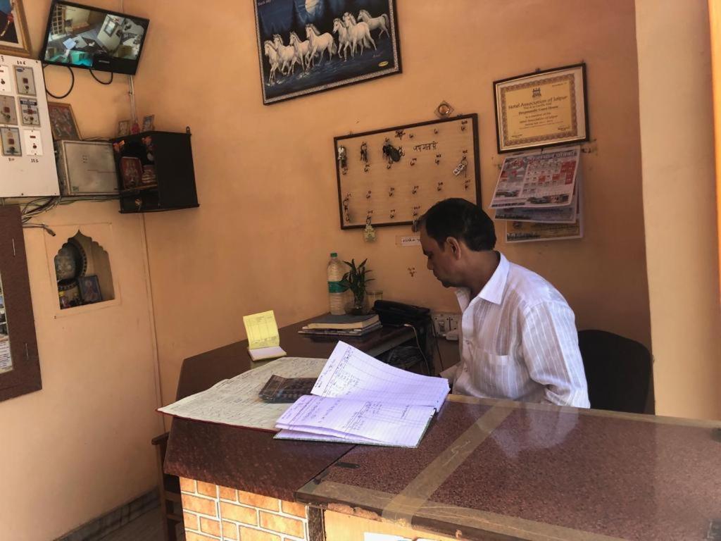 Een man aan een balie in een koffiehuis. bij Hotel Deep Mandir in Jaipur
