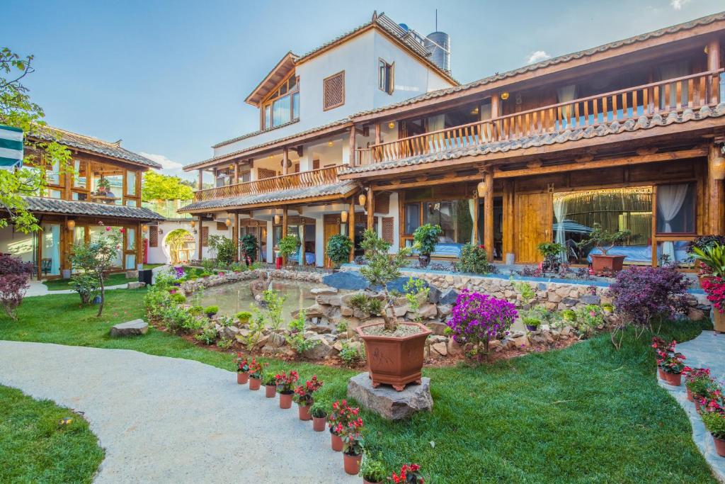 una casa grande con un patio con flores en Swallow Nest Guesthouse, en Kunming