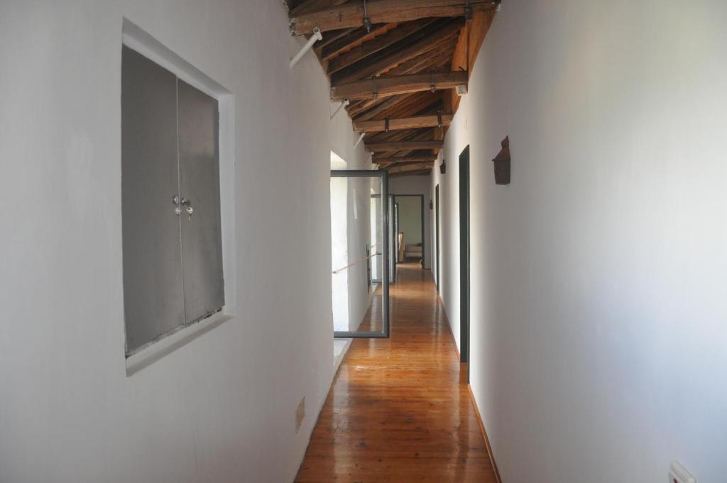 an empty hallway with white walls and wooden ceilings at Convento de São Francisco in Vila Franca do Campo