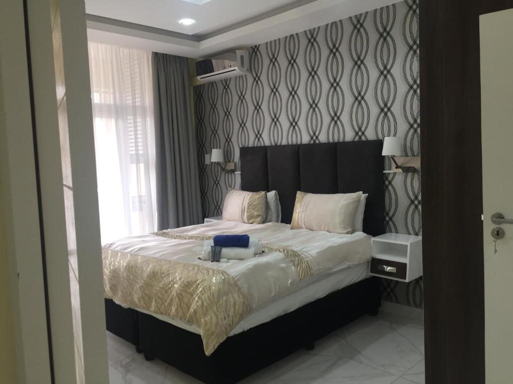 a bedroom with a large bed with a black headboard at AYA LUXURY APARTMENTS 99 in Durban