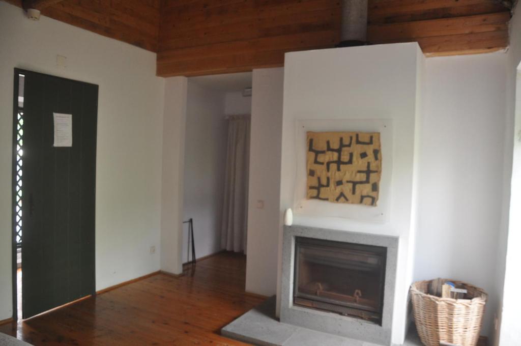 a living room with a fireplace and a painting on the wall at Convento de São Francisco in Vila Franca do Campo