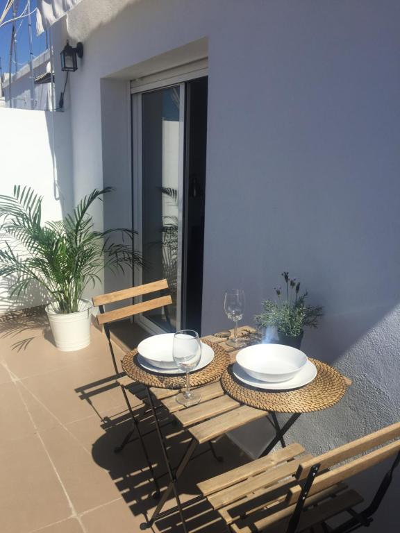 einen Tisch und Stühle auf dem Balkon eines Hauses in der Unterkunft Penthouse Asuncion Feria in Sevilla