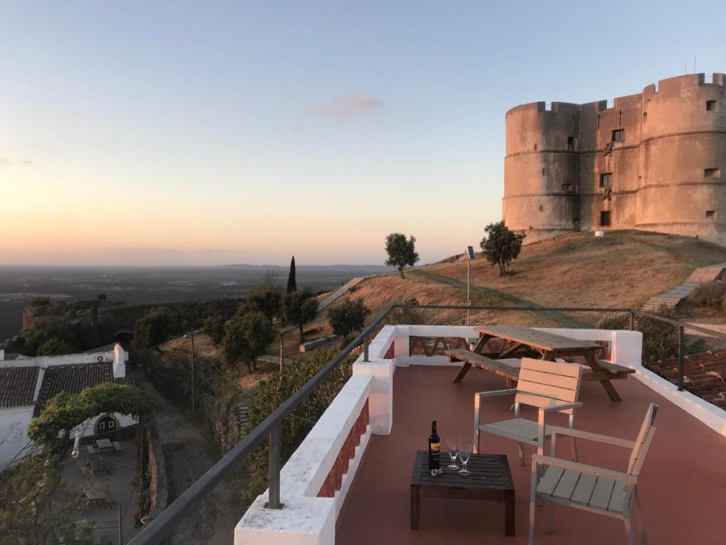 uma varanda com uma mesa e cadeiras e um castelo em The Place at Evoramonte em Évora Monte