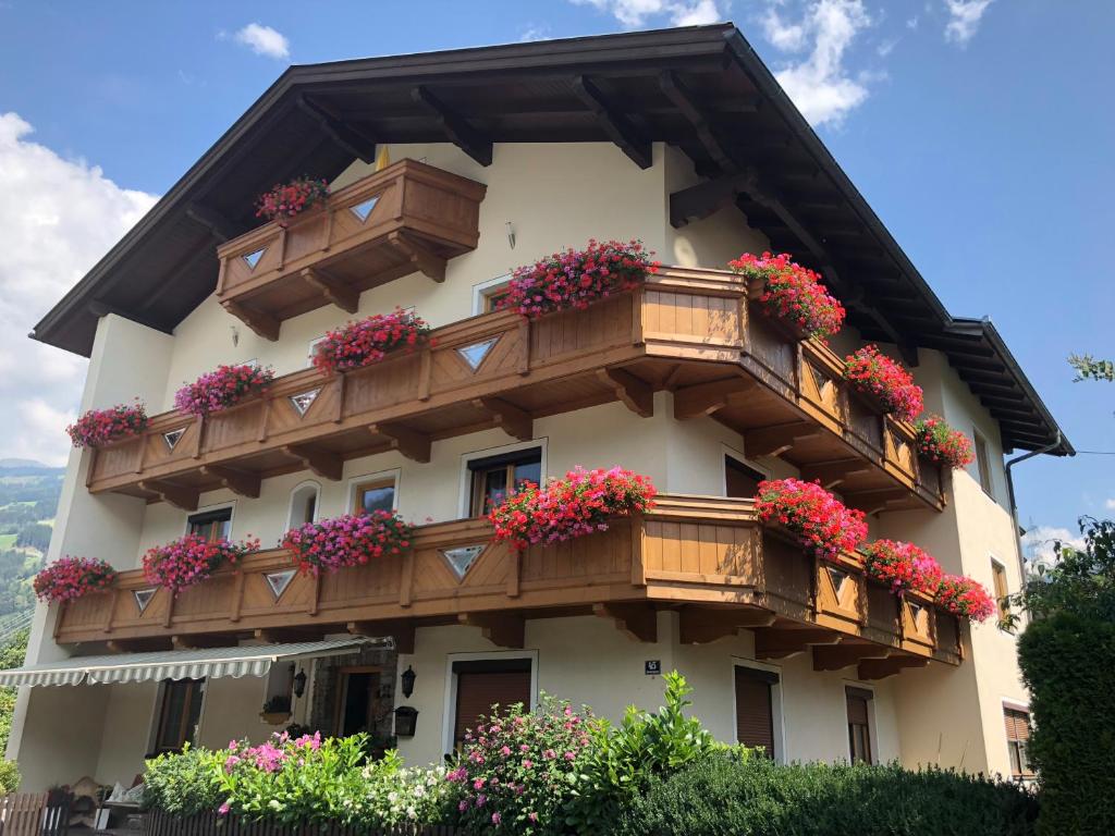 ein Gebäude mit Blumenkästen auf den Balkonen in der Unterkunft Gästehaus Neuhauser in Zell am Ziller