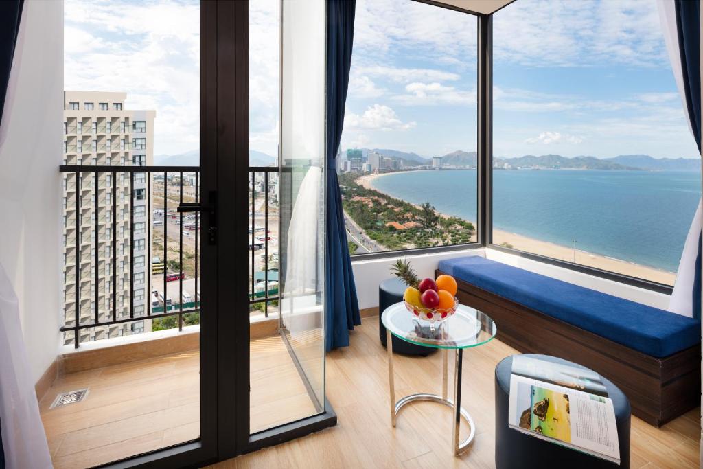 a room with a balcony with a view of the ocean at Crown Hotel Nha Trang in Nha Trang