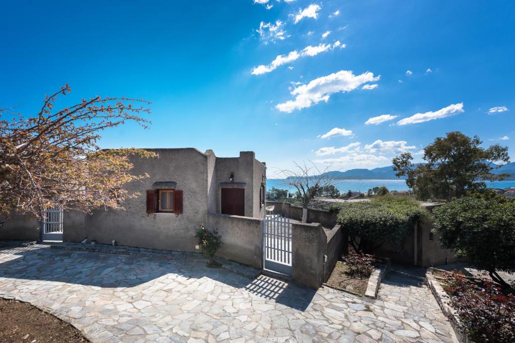 a house with a gate and a stone patio at Cavo Grosso Bungalows in Mavrovouni