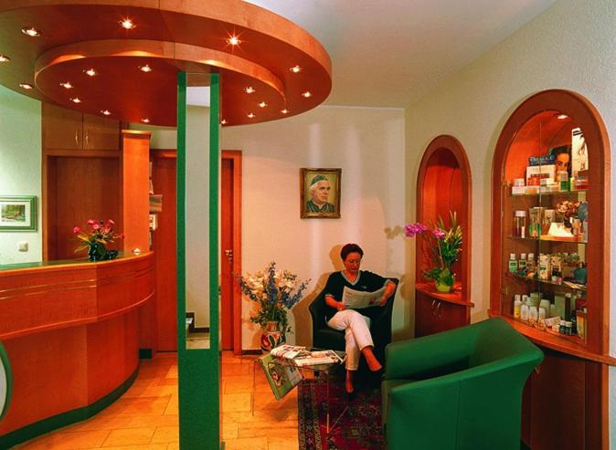 a woman sitting in a chair at a pharmacy at Kurhotel Weber in Bad Wörishofen