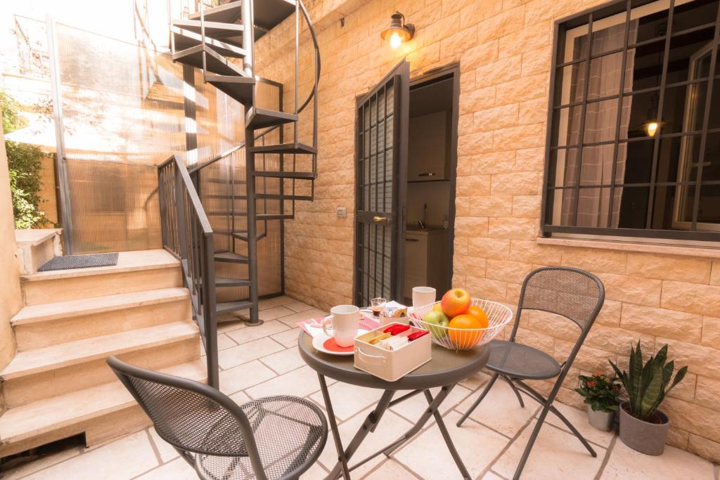 eine Terrasse mit einem Tisch und einer Obstschale darauf in der Unterkunft Leonina 75 Holidays in Rom
