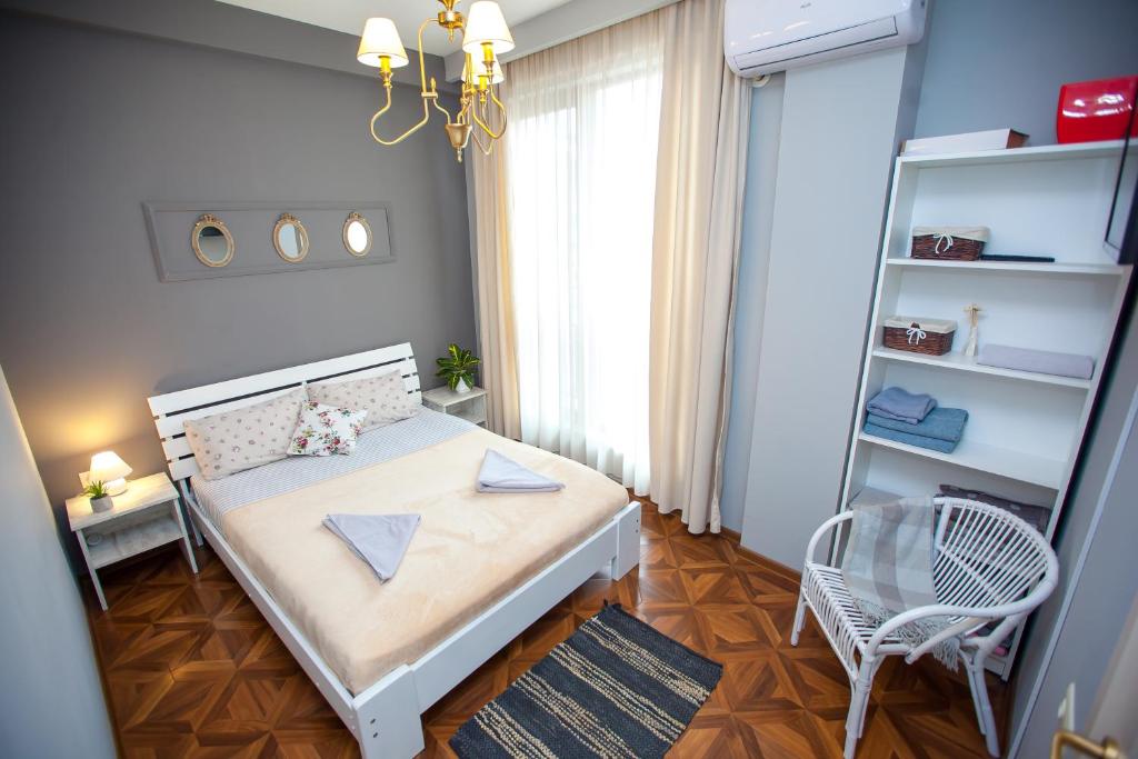 um pequeno quarto com uma cama e uma cadeira em Tbilisi LOA Apartment em Tbilisi