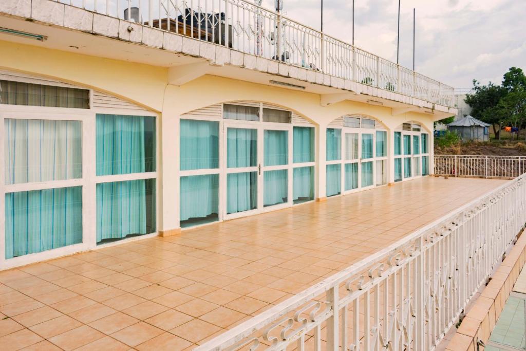 einen Balkon eines Gebäudes mit einer Holzterrasse in der Unterkunft Sunrise Apartments Hotel Fort Portal in Fort Portal