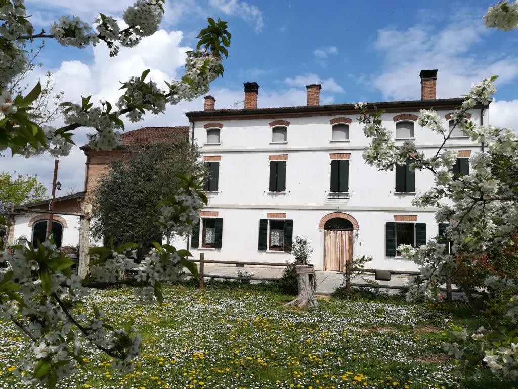 een oud huis met een tuin ervoor bij Agriturismo Loghino Sabbioni in Suzzara