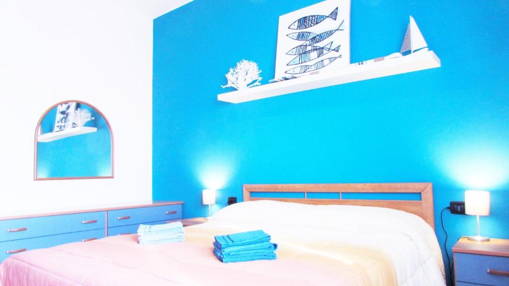 Dormitorio azul con cama y pared azul en Casa San Raffaele, en Vimodrone