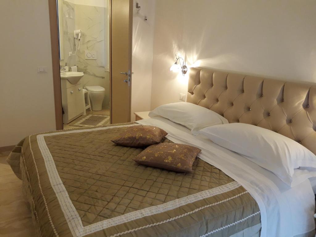 a bedroom with a large bed with two pillows on it at Affittacamere Sorrento in Ventimiglia