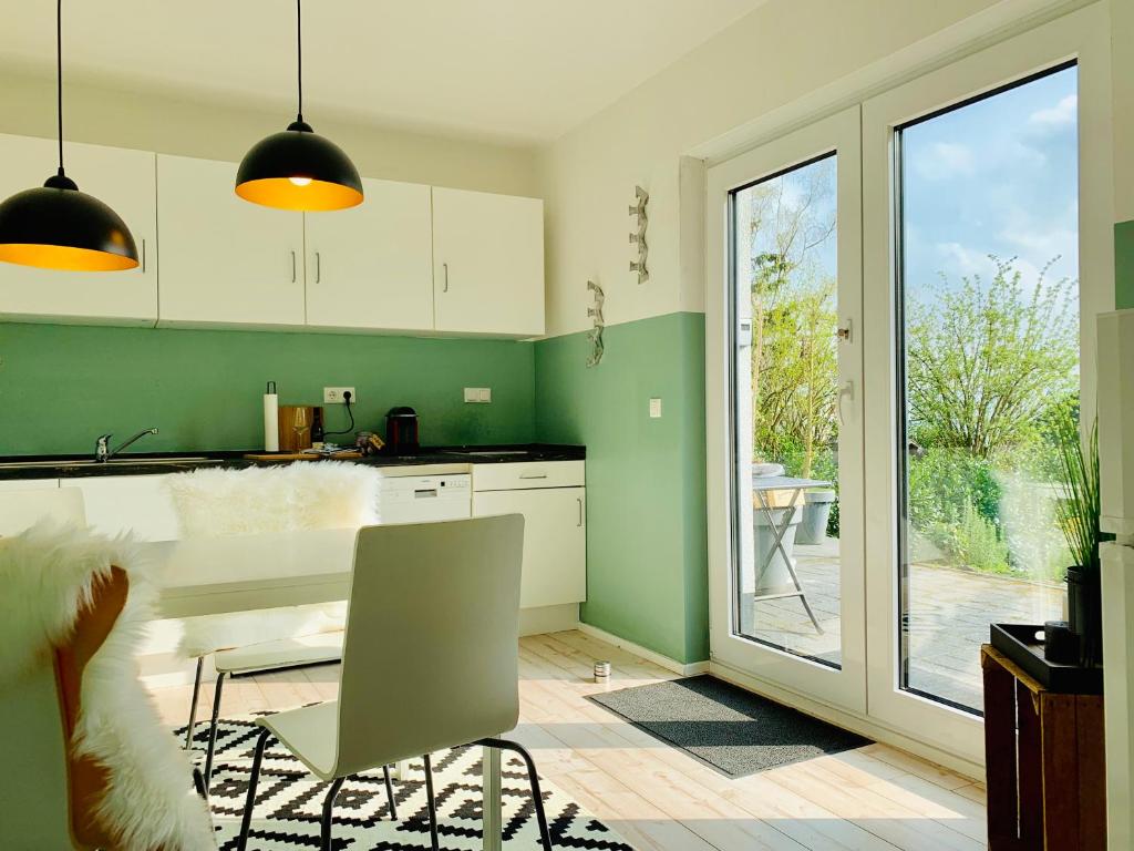 una cocina con paredes verdes y una mesa con una silla en Ferienwohnung Oberwinter, en Bandorf