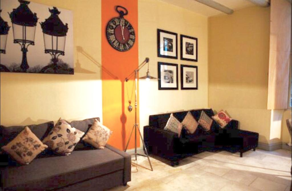 sala de estar con sofá y reloj en la pared en Appartement La Masse, en Aviñón