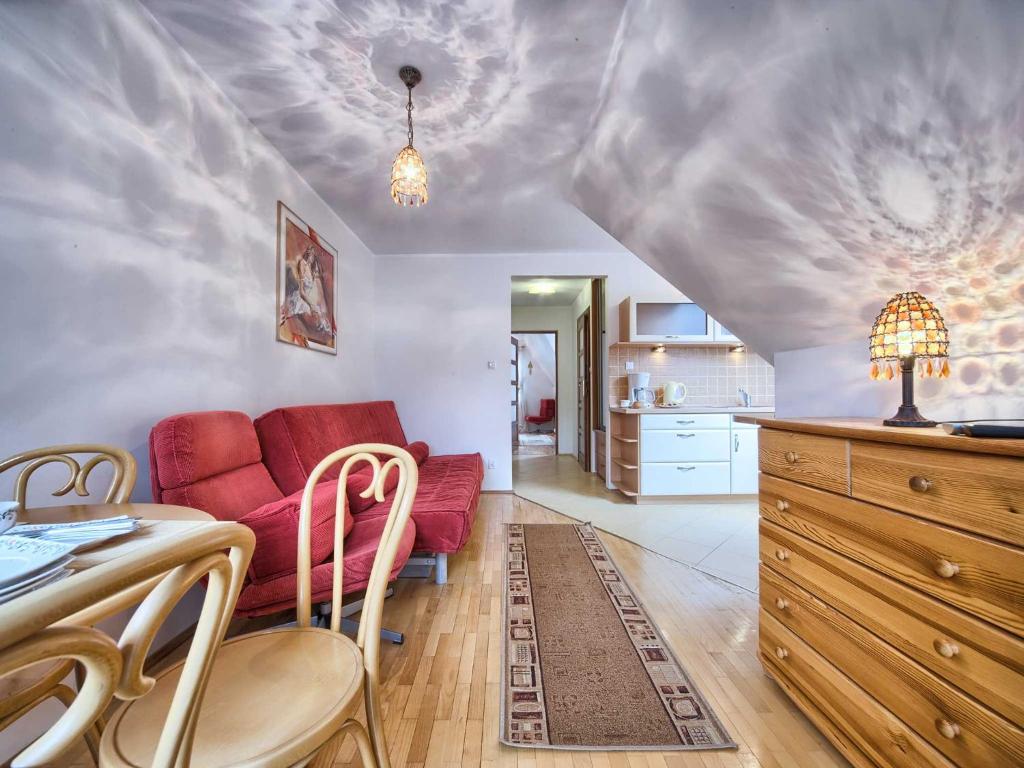 salon z czerwoną kanapą i kuchnią w obiekcie VisitZakopane - Himalaya Apartment w Zakopanem