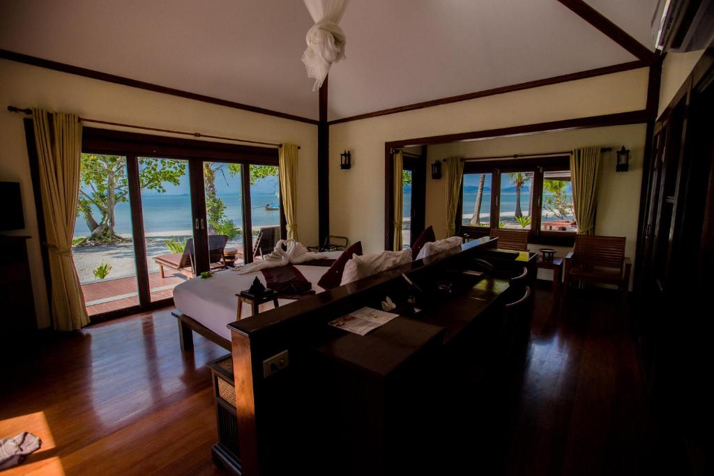 a living room with a bed and tables and chairs at Koh Mook Sivalai Beach Resort in Ko Mook