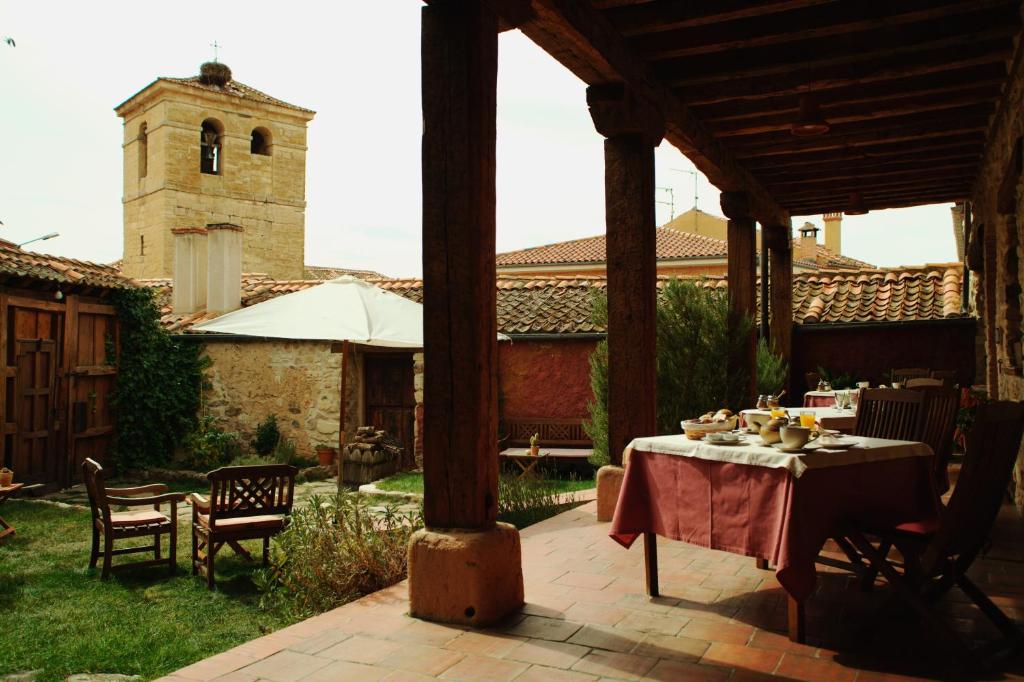 een patio met een tafel en stoelen en een kerk bij Casona de Espirdo in Espirdo