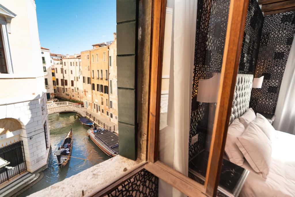 einen Balkon mit Blick auf einen Kanal und eine Brücke in der Unterkunft Domus Superior in Venedig