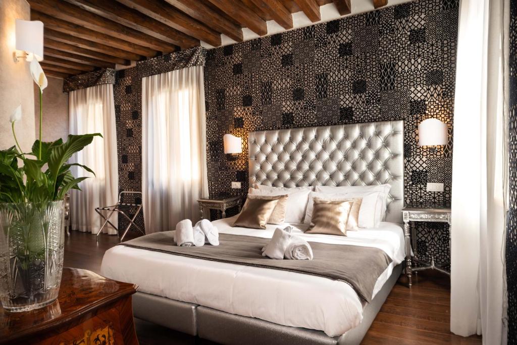 a bedroom with a large bed with two white towels at Domus Superior in Venice