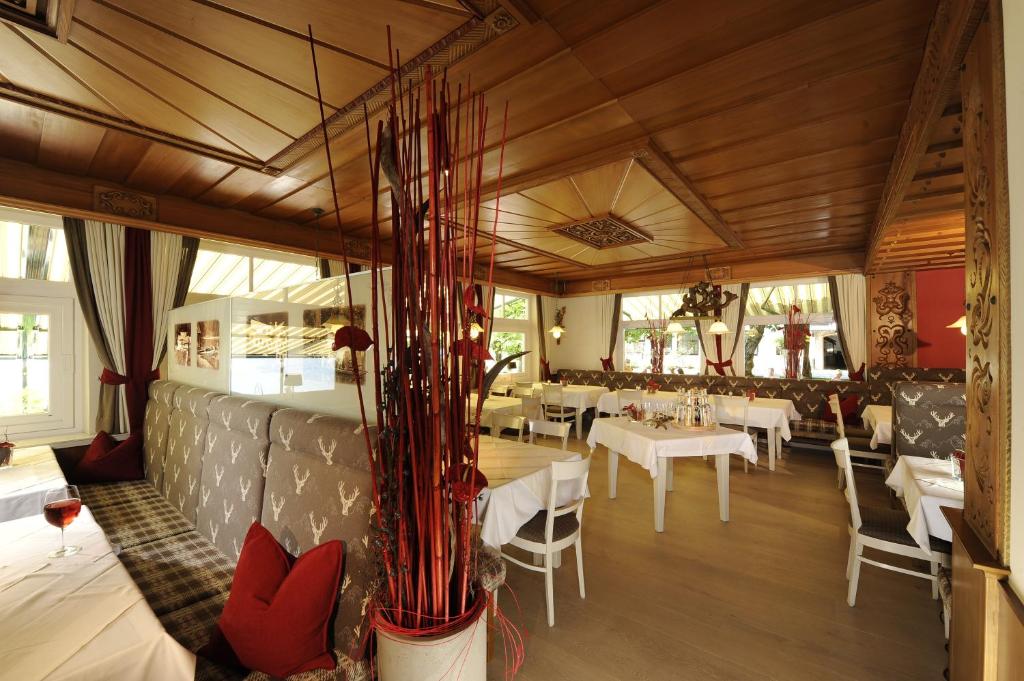 a dining room with white tables and chairs at Hotel & Gasthof Fürberg in Sankt Gilgen