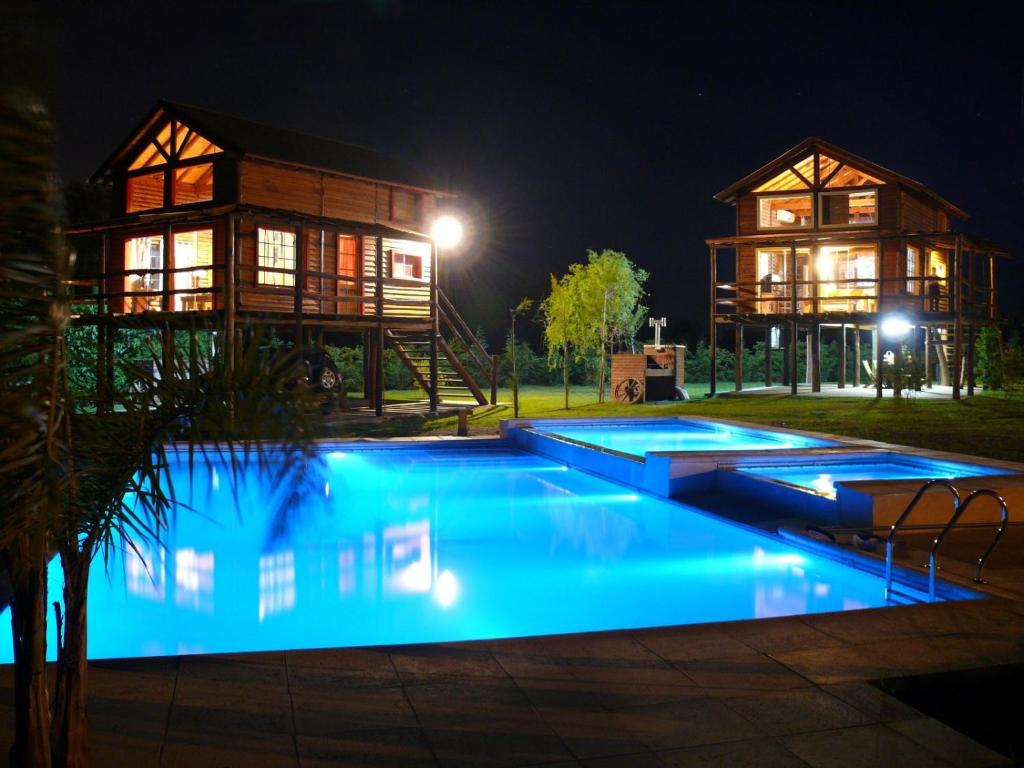 una casa con piscina azul por la noche en Cabañas de la Ribera en San Pedro