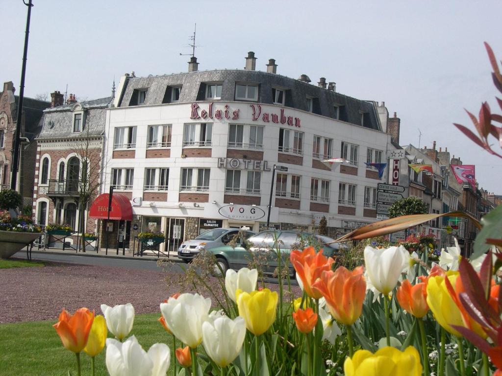 Un bâtiment avec un bouquet de fleurs devant lui dans l'établissement Le Relais Vauban, à Abbeville