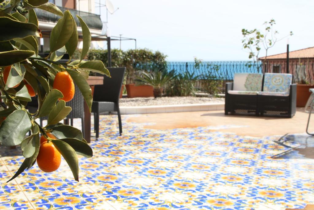 a rug on a patio with an orange tree at Taonasi Taormina Apartments in Taormina