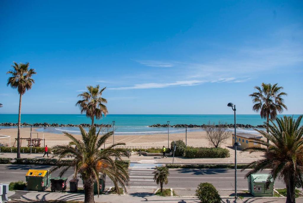 vista su una spiaggia con palme e sull'oceano di Appartamento di Antonio fronte Mare a Montesilvano