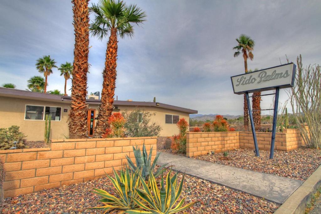 ein Schild vor einem Haus mit Palmen in der Unterkunft Lido Palms Resort & Spa in Desert Hot Springs