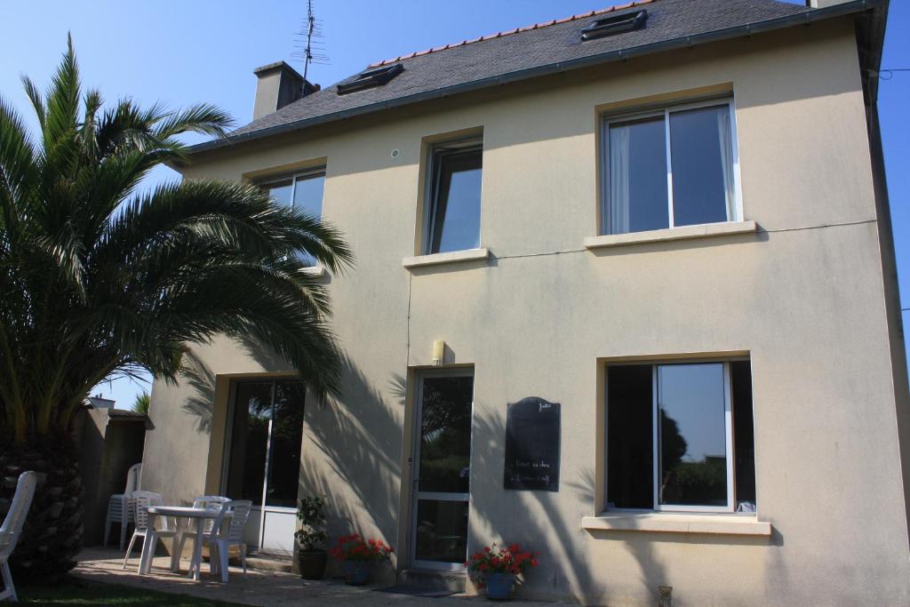 a house with a palm tree in front of it at Pension de Kerioual in Roscoff