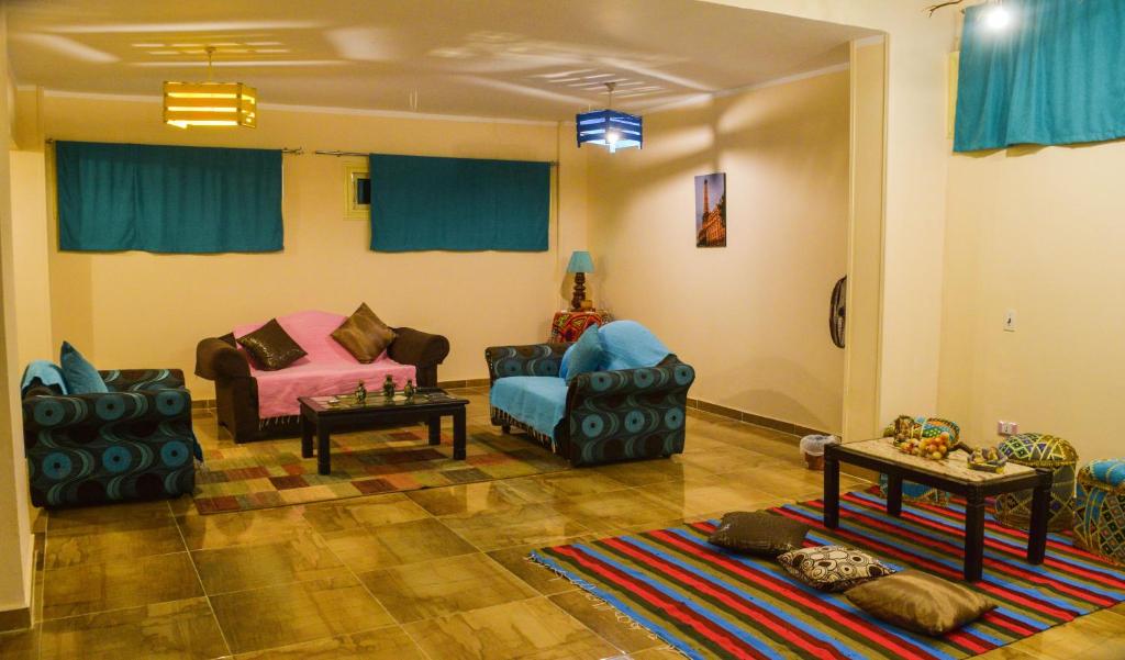 uma sala de estar com duas cadeiras e um sofá em Jamila Apartment For Families no Cairo