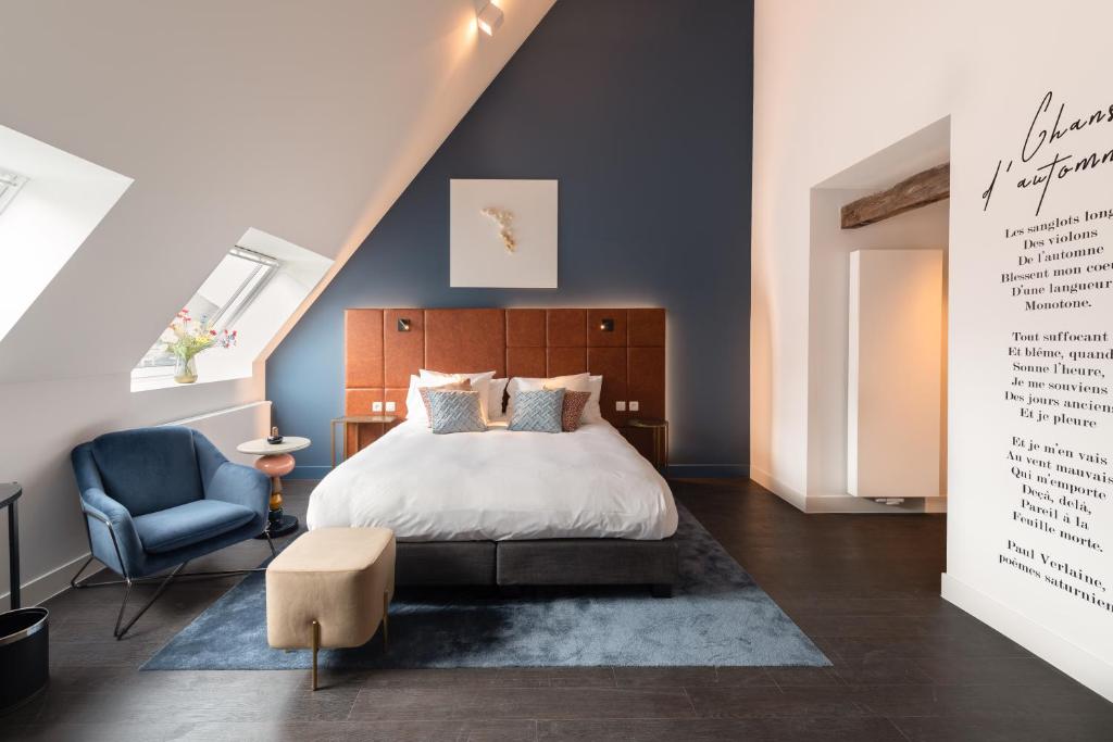 a bedroom with a bed and a blue chair at Boutique Hotel Sablon in Bruges