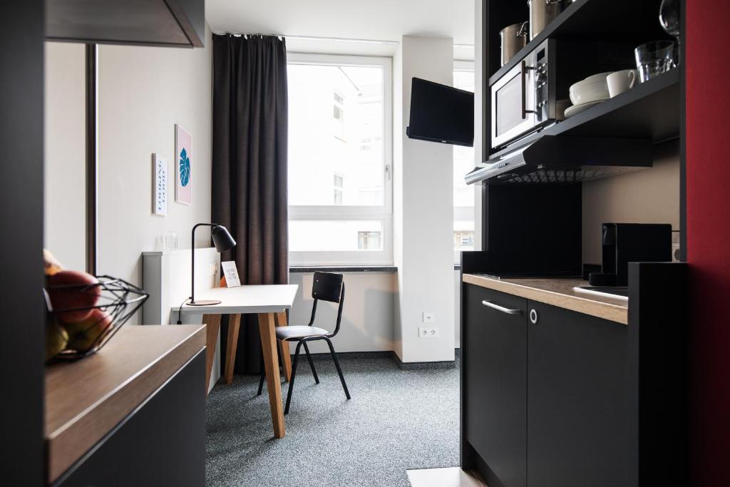 a small kitchen with a table and a chair at HUB Apartments in Hamburg