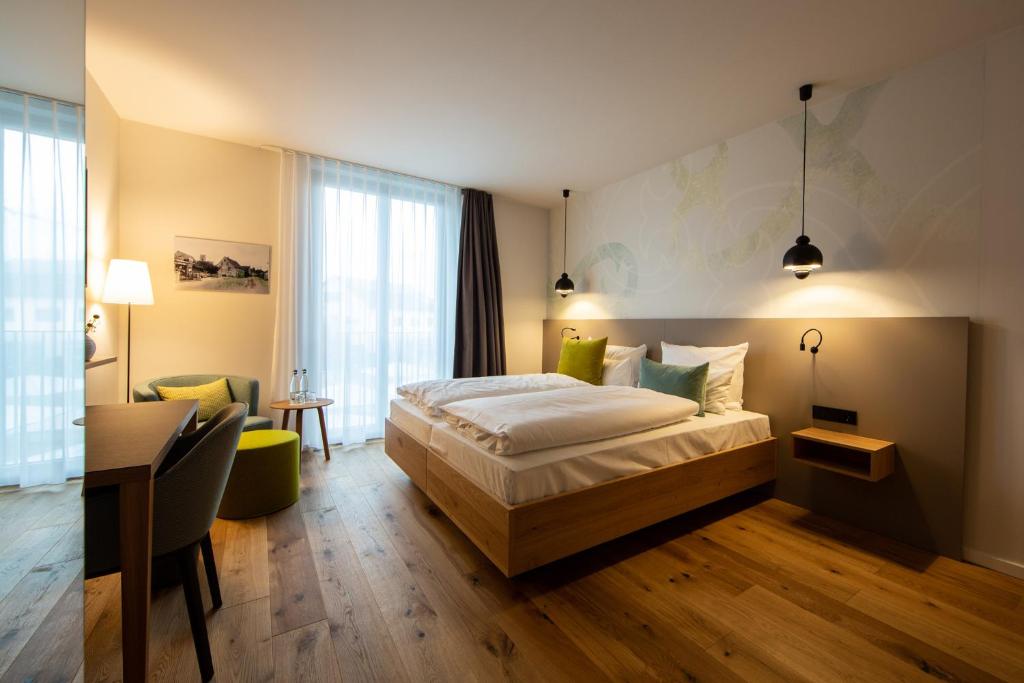 a hotel room with a bed and a desk at zum LOEWEN in Eimeldingen